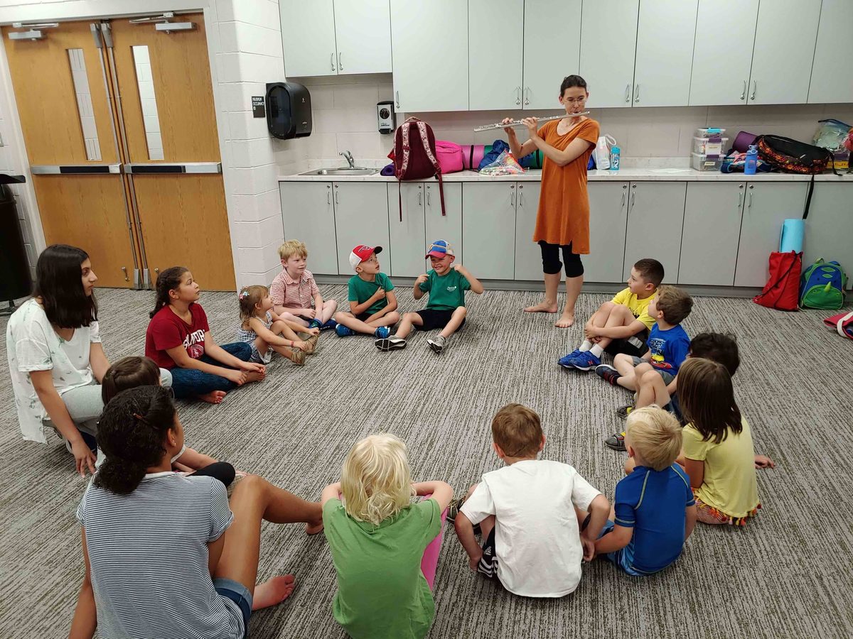 Flute performance for children sitting in a circle