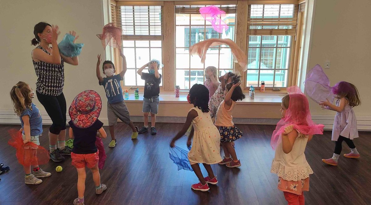 Children moving with scarves in a music and movement class